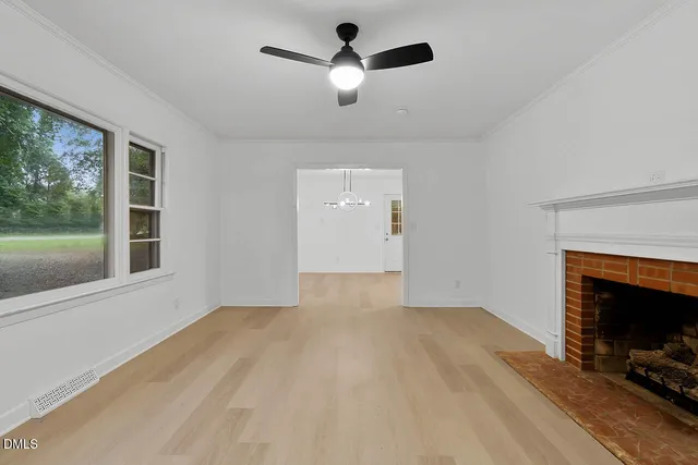 an empty room with a fireplace and a window