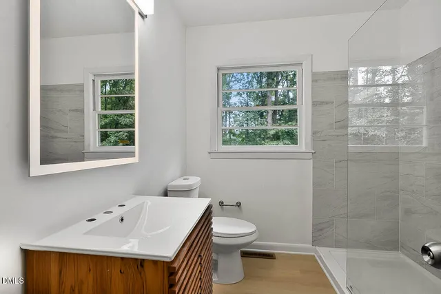 a spacious bathroom with a granite countertop sink a toilet and a bathtub