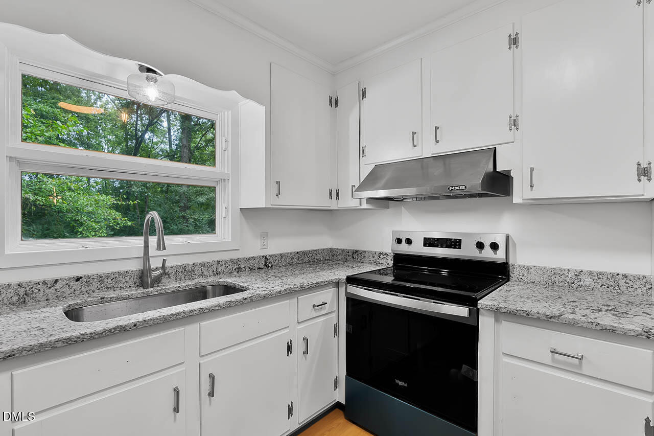 3508 Old US 1 Highway New Hill, NC 27562 - Photo 10 of 23 a kitchen with granite countertop white cabinets and a window