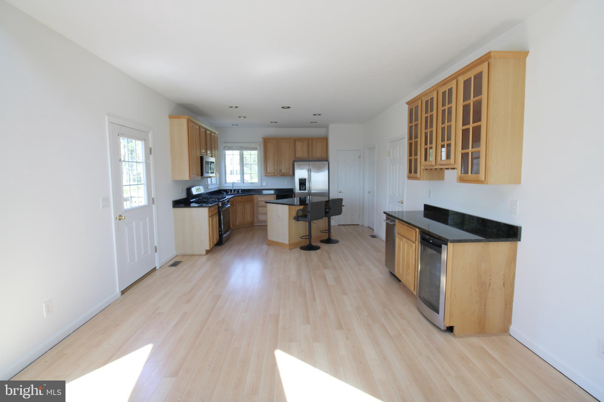 40461 Old Breton Beach Road Leonardtown, MD 20650 - Photo 14 of 61 a kitchen with granite countertop wooden floors and stainless steel appliances