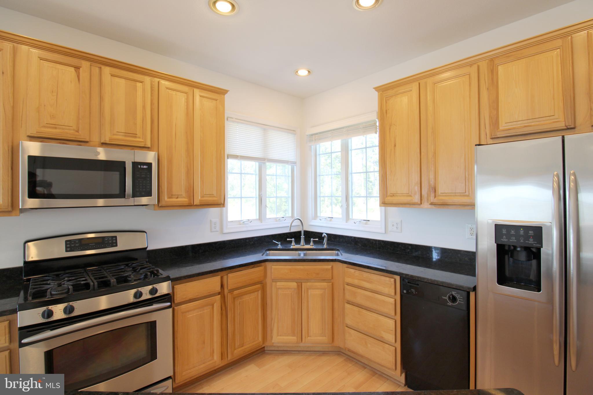 40461 Old Breton Beach Road Leonardtown, MD 20650 - Photo 18 of 61 a kitchen with stainless steel appliances granite countertop a stove a sink and a microwave