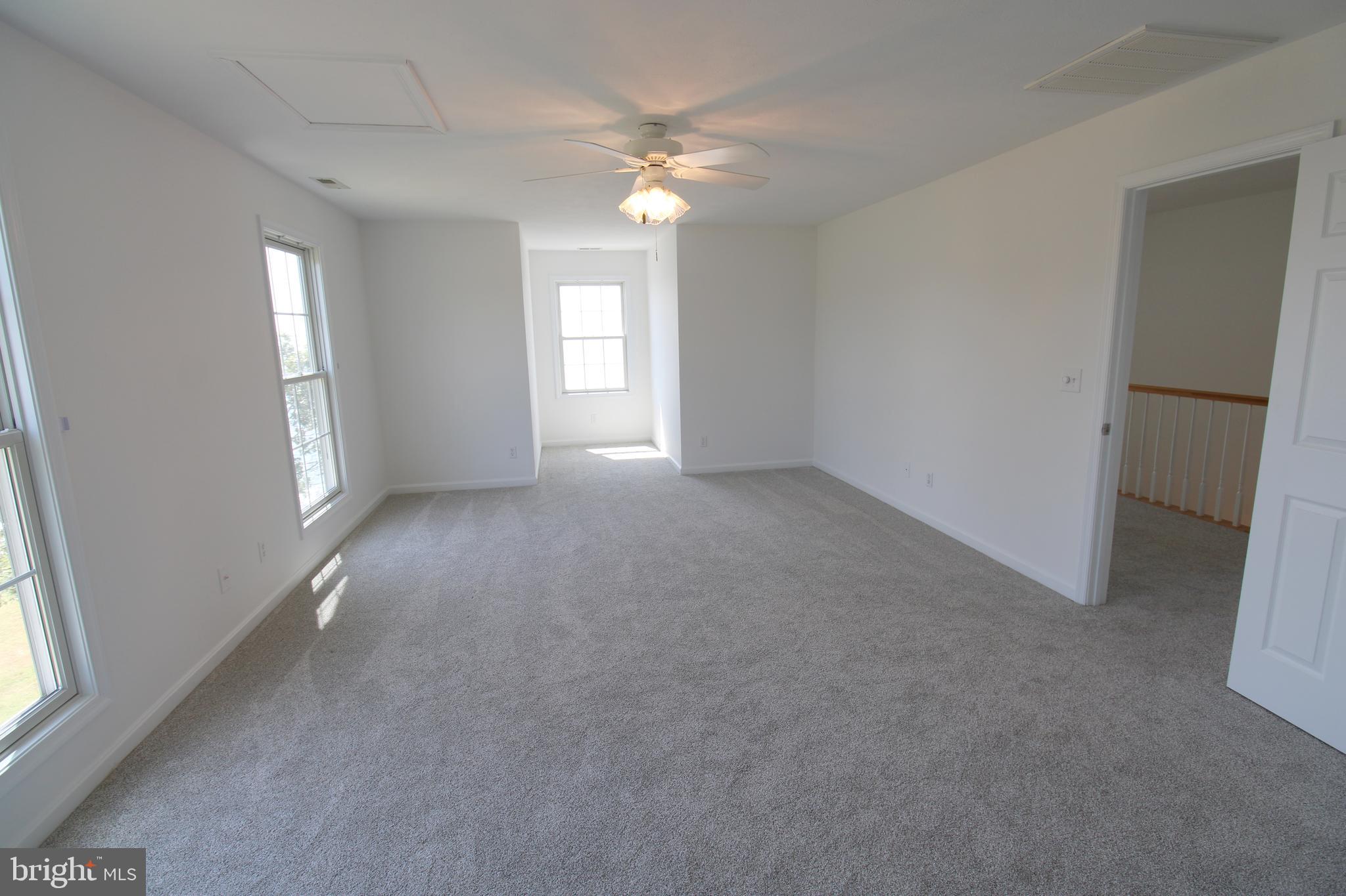 40461 Old Breton Beach Road Leonardtown, MD 20650 - Photo 44 of 61 an empty room with windows and chandelier fan