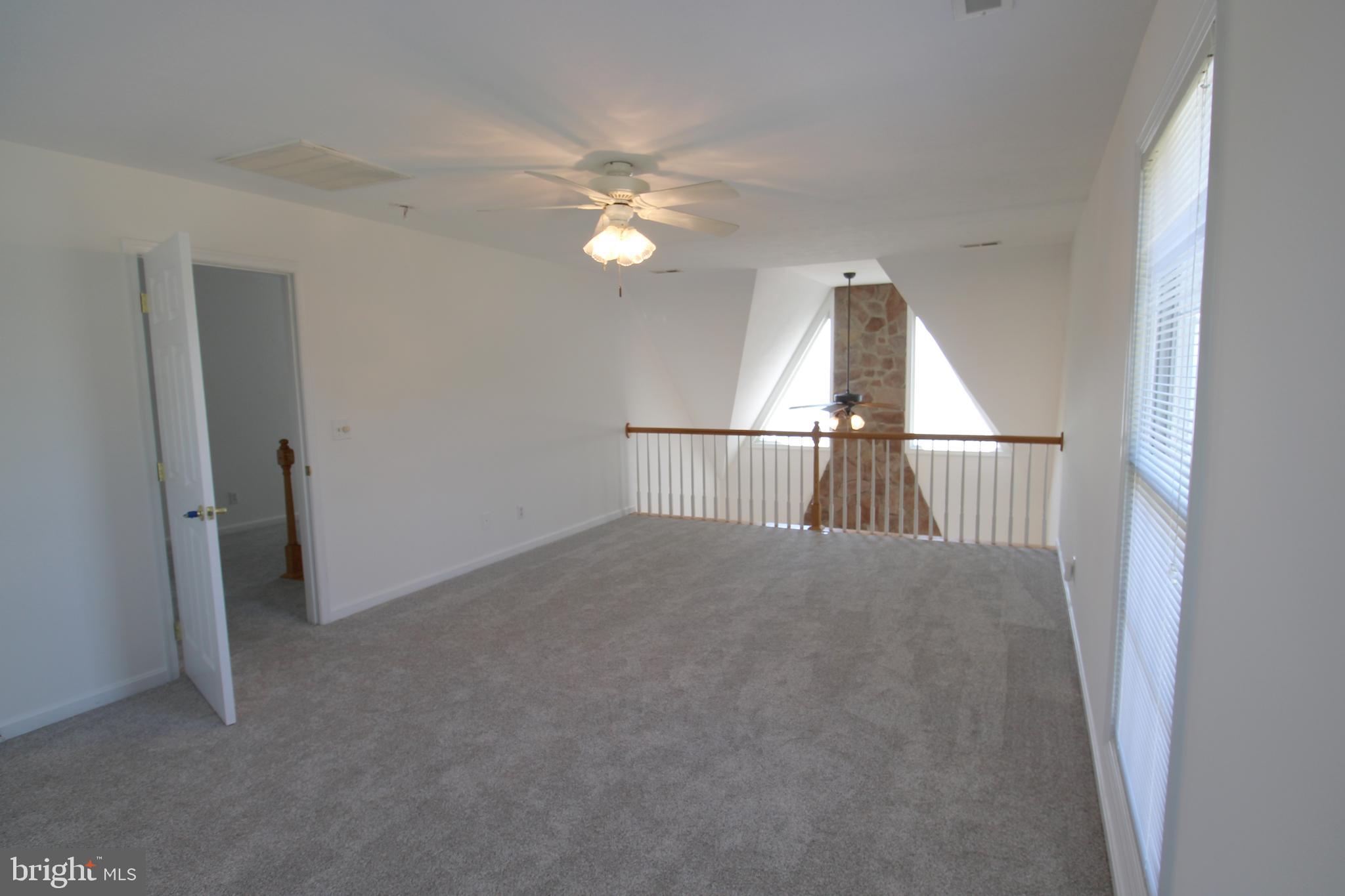 40461 Old Breton Beach Road Leonardtown, MD 20650 - Photo 46 of 61 an empty room with chandelier fan and windows