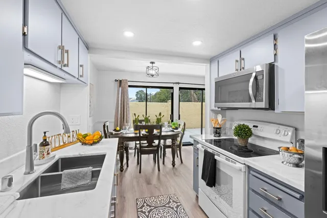 a kitchen with a sink a counter space appliances and cabinets
