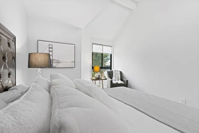 a bedroom with a large bed and a chandelier