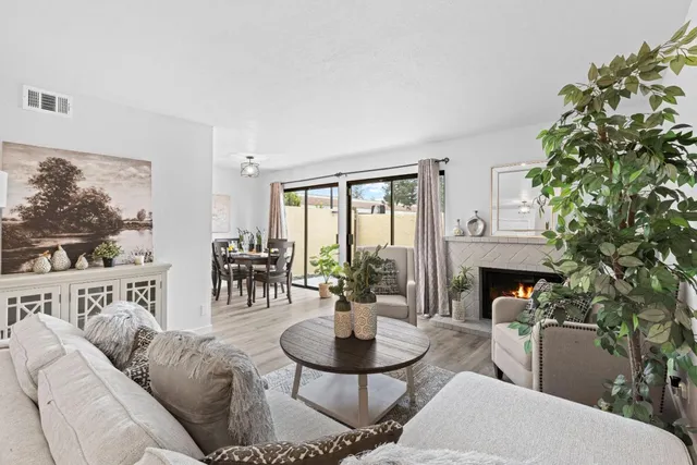 a living room with furniture a fireplace and a flat screen tv
