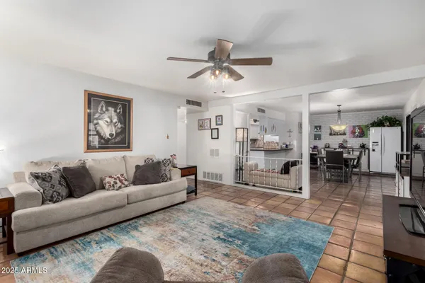 a living room with furniture and a dining table with kitchen view