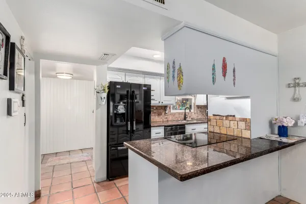 a kitchen with stainless steel appliances granite countertop a sink refrigerator and cabinets