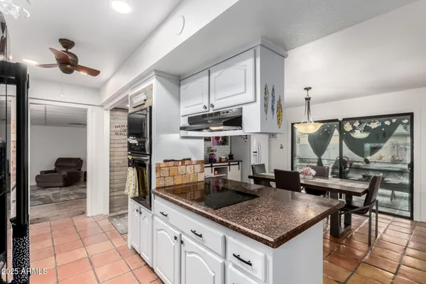 a kitchen with granite countertop a sink cabinets and stainless steel appliances