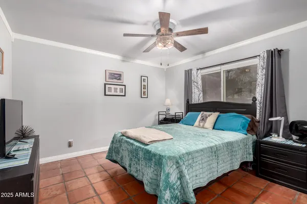 a bedroom with a bed and a flat tv screen on the dresser