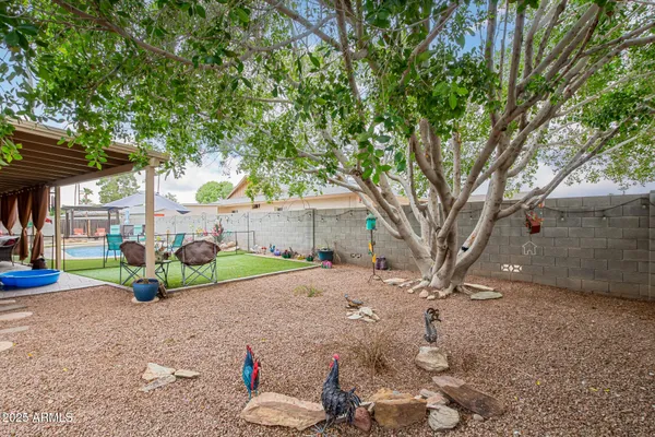 a backyard of a house with table and chairs under an umbrella