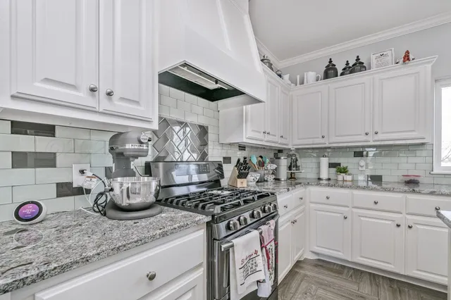 a view of a kitchen counter top space with granite countertop wooden floor