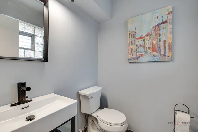 a bathroom with a toilet a sink and mirror