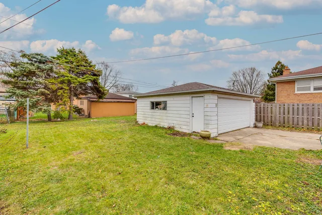 a front view of house with yard and trees in the background