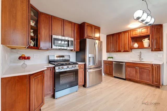 a kitchen with stainless steel appliances granite countertop a stove refrigerator sink and microwave