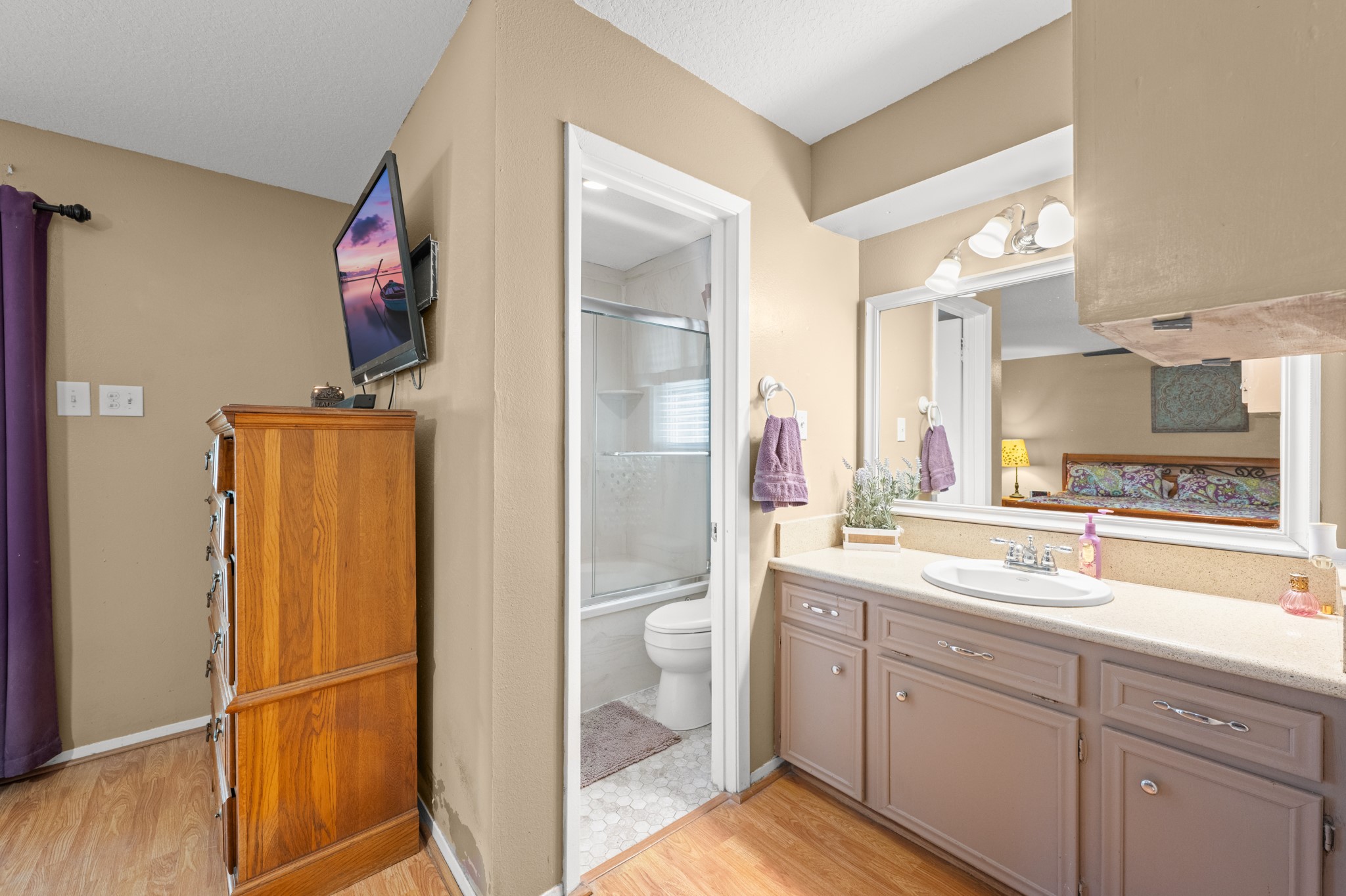 15602 Fir Road Santa Fe, TX 77517 - Photo 19 of 42 Spacious primary bath vanity area featuring generous counter space, ample cabinetry, and a large mirror with updated lighting. The functional layout offers convenient access to the private bath and shower area for added comfort and privacy.
