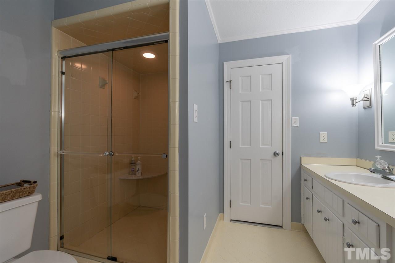 11621 Coachmans Way Raleigh, NC 27614 - Photo 16 of 30 a bathroom with a shower sink vanity and mirror