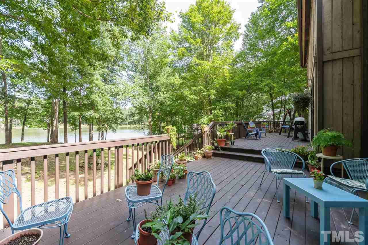 11621 Coachmans Way Raleigh, NC 27614 - Photo 25 of 30 a view of a patio with couches table and chairs and potted plants with wooden floor and fence
