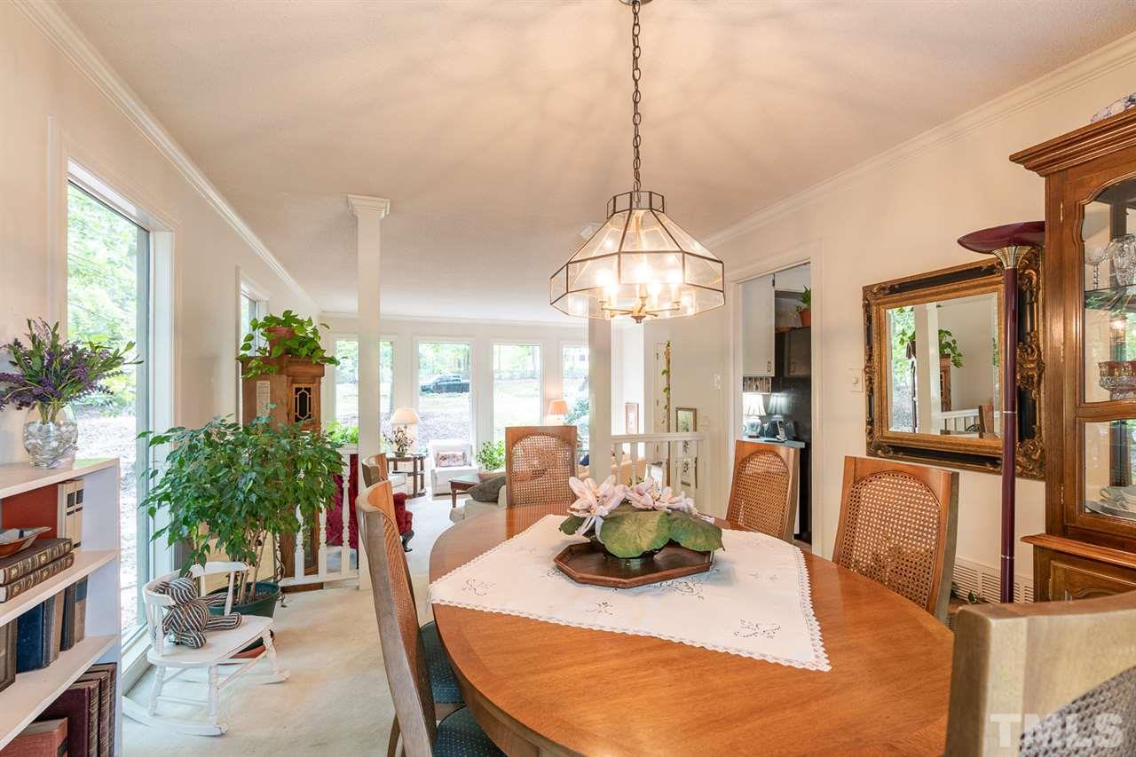 11621 Coachmans Way Raleigh, NC 27614 - Photo 5 of 30 a view of a dining room and livingroom with furniture large windows wooden floor and a chandelier