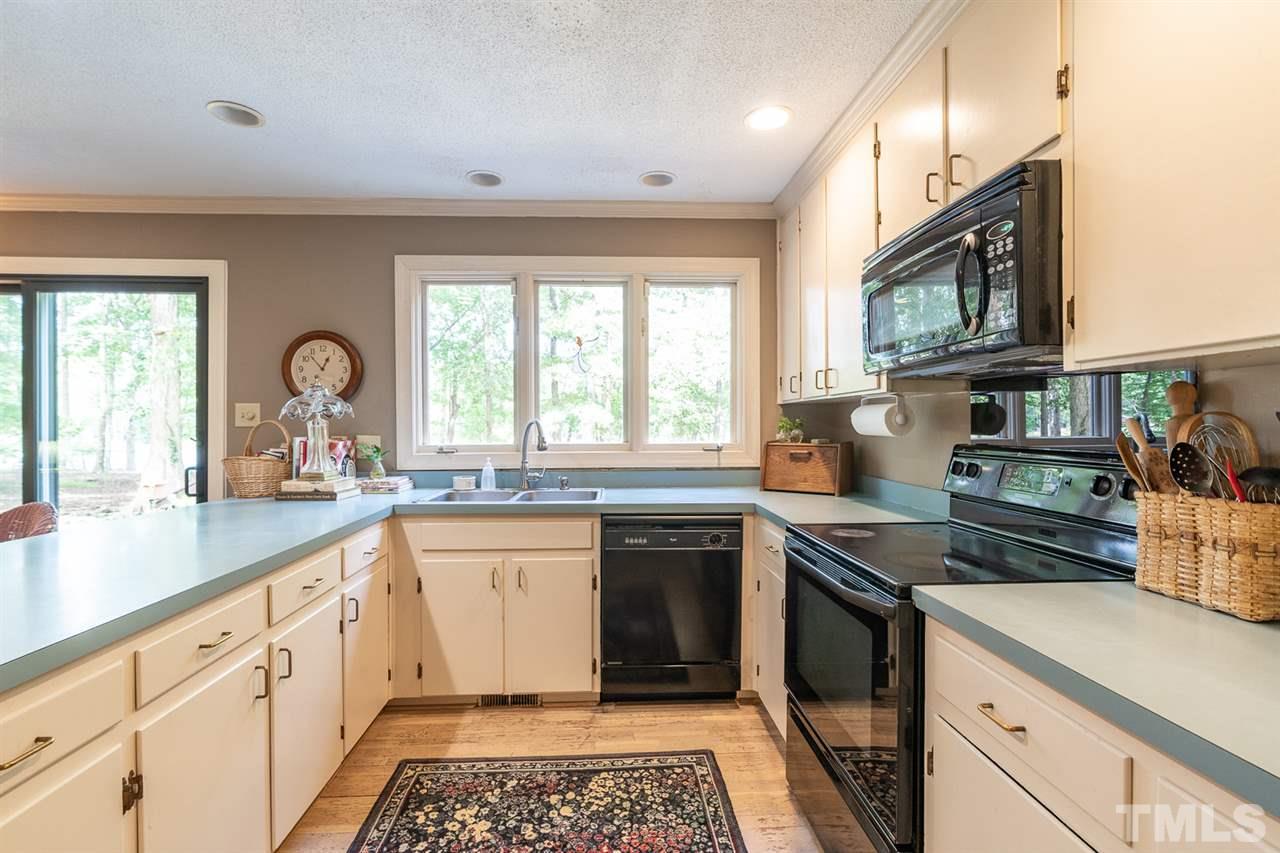 11621 Coachmans Way Raleigh, NC 27614 - Photo 6 of 30 a kitchen with stainless steel appliances granite countertop a stove a sink and a microwave