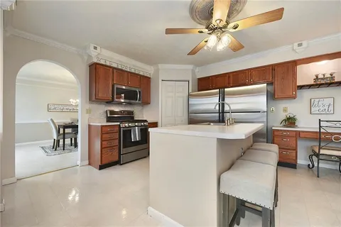 a kitchen with stainless steel appliances kitchen island granite countertop a sink cabinets and microwave