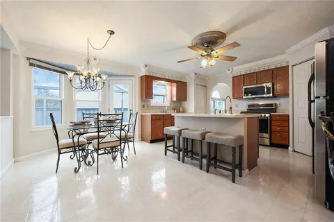 a dining room with furniture a chandelier and kitchen view
