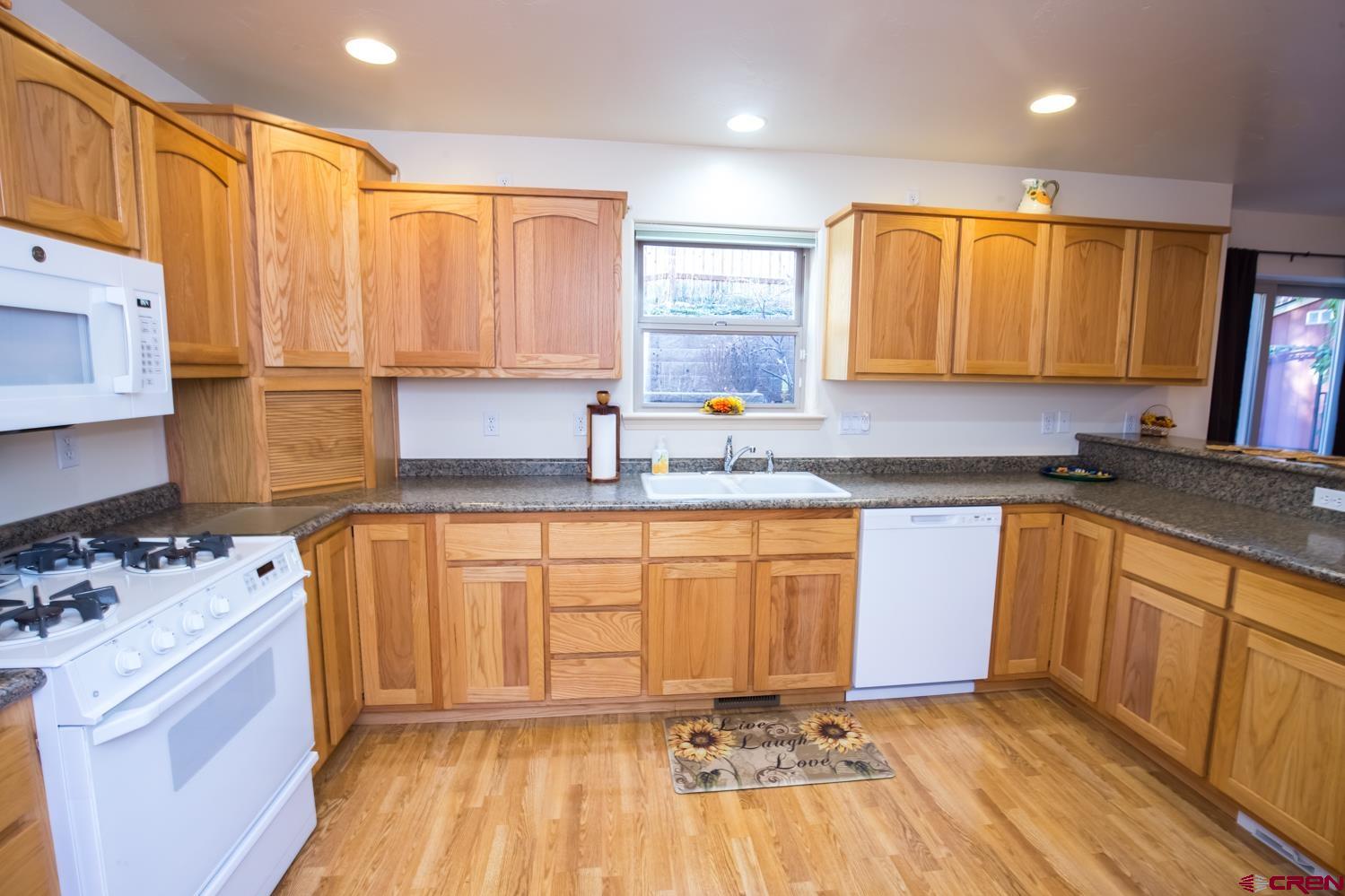 334 Jenkins Ranch Road Durango, CO 81301 - Photo 11 of 35 a kitchen with granite countertop a sink stove and cabinets