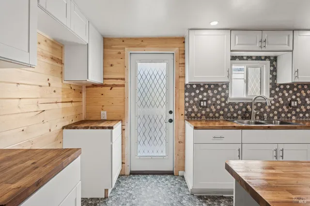 a large kitchen with stainless steel appliances wooden floor and a refrigerator