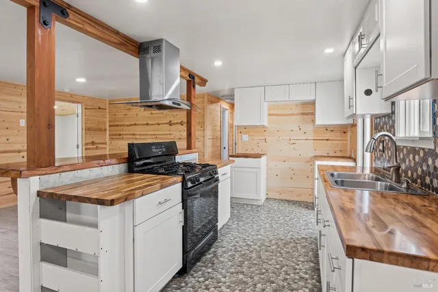 a kitchen with stainless steel appliances granite countertop a stove and a large window