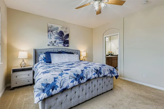 a bedroom with a bed a chandelier and a painting on the wall