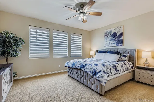 a bed sitting in a bedroom next to a window with a chandelier