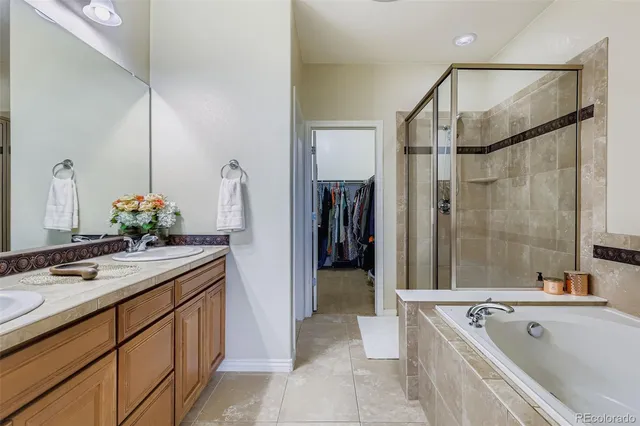 a spacious bathroom with a tub sink and mirror