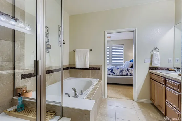 a bathroom with a tub a sink and a large mirror