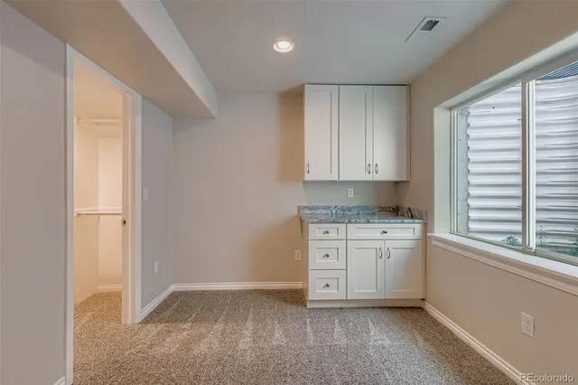 a kitchen with granite countertop white cabinets and white appliances
