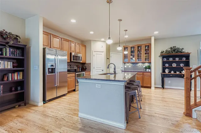 a kitchen with stainless steel appliances granite countertop a refrigerator a stove top oven and a center island