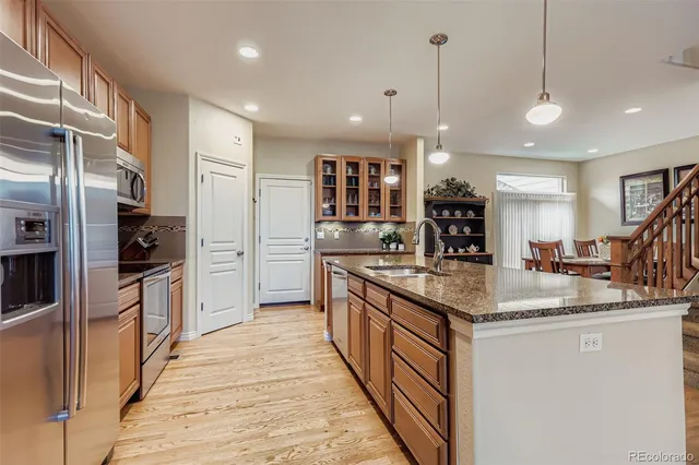 a kitchen with stainless steel appliances granite countertop a sink a stove and a refrigerator