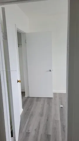 an empty room with wooden floor and white door