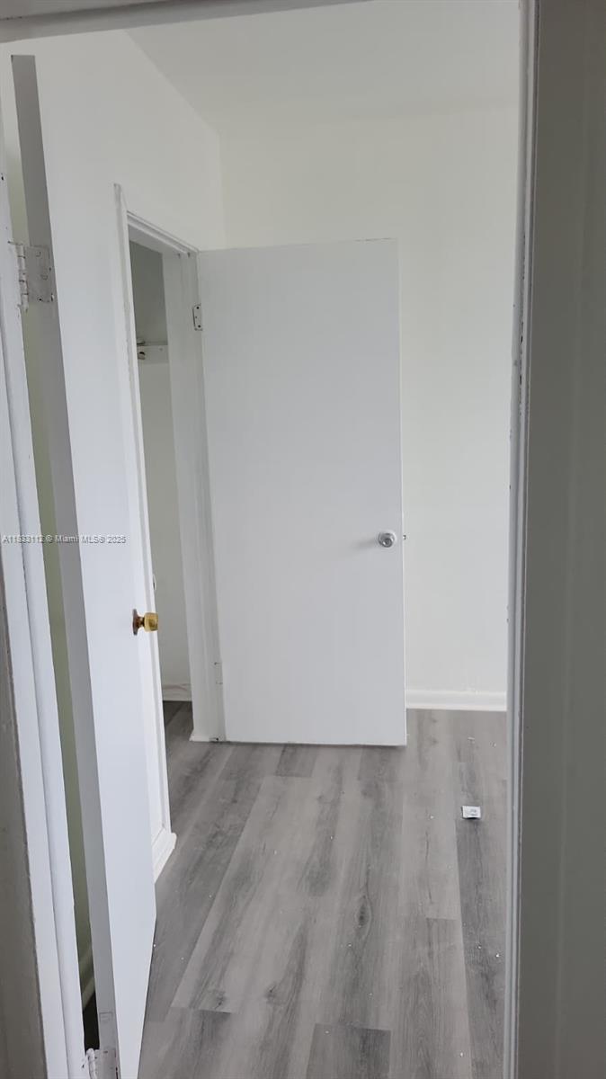 1406 Northwest 2nd Avenue, Unit 2 Florida City, FL 33034 - Photo 7 of 10 an empty room with wooden floor and white door