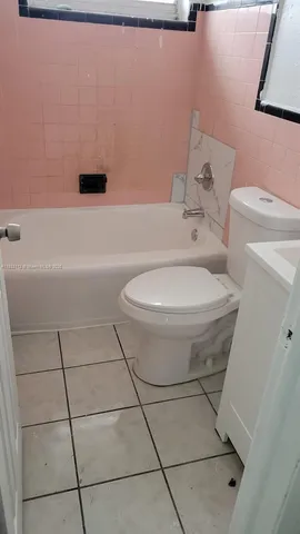 a white toilet sitting next to a bath tub