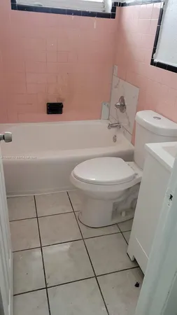 a white toilet sitting next to a bath tub