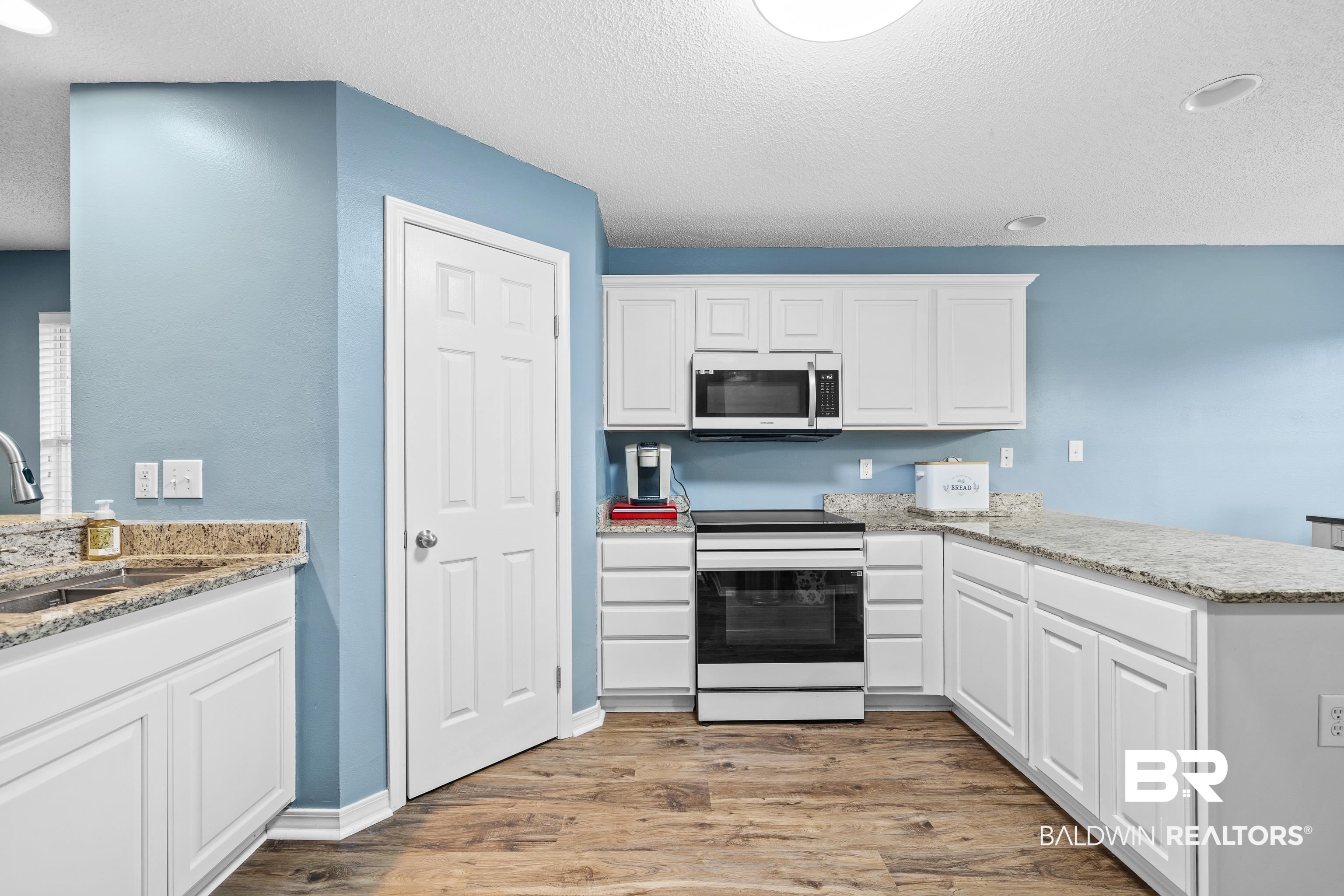 9552 Collier Loop Daphne, AL 36526 - Photo 9 of 28 Kitchen with electric range, a sink, light wood-style flooring, a peninsula, and white cabinetry
