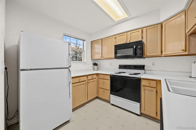 a kitchen with stainless steel appliances granite countertop a refrigerator stove a sink and a microwave