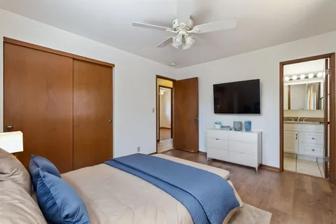a bedroom with a bed flat screen tv and a couch