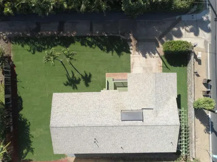 an aerial view of a house with a yard and lake view