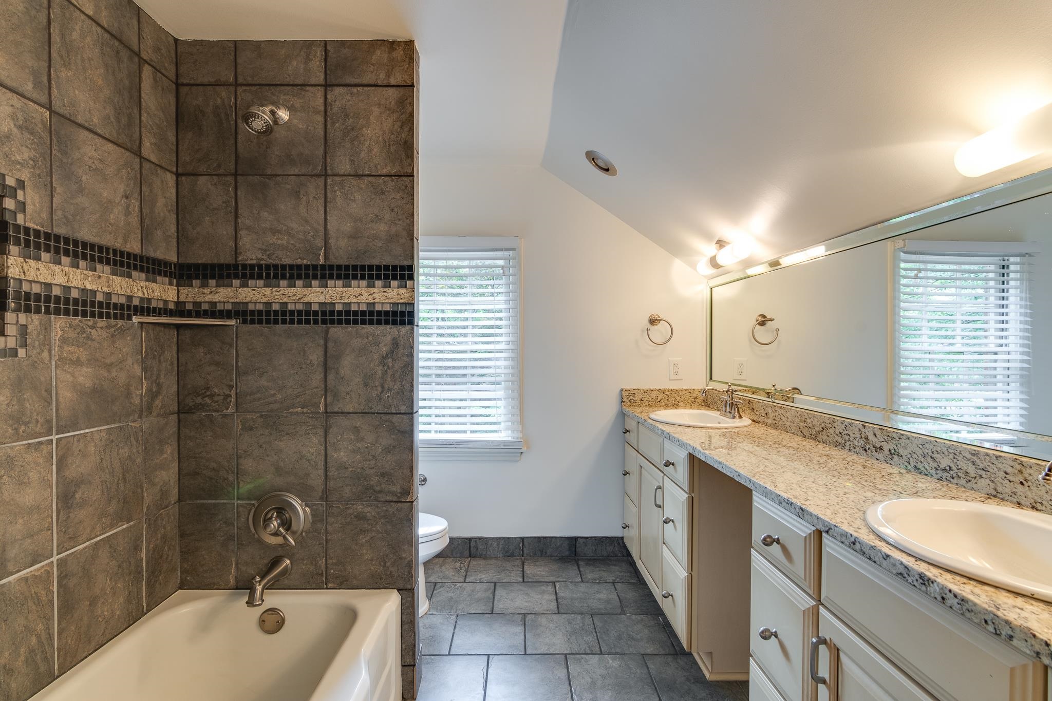 359 Roseland Place Memphis, TN 38111 - Photo 31 of 38 Full bathroom with vaulted ceiling, double vanity, a wealth of natural light, toilet, and tile floors