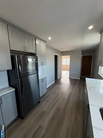 a view of a refrigerator in kitchen and wooden floor