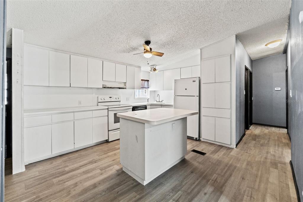 7610 County Road 663 Bushnell, FL 33513 - Photo 12 of 43 a kitchen with white cabinets and white appliances