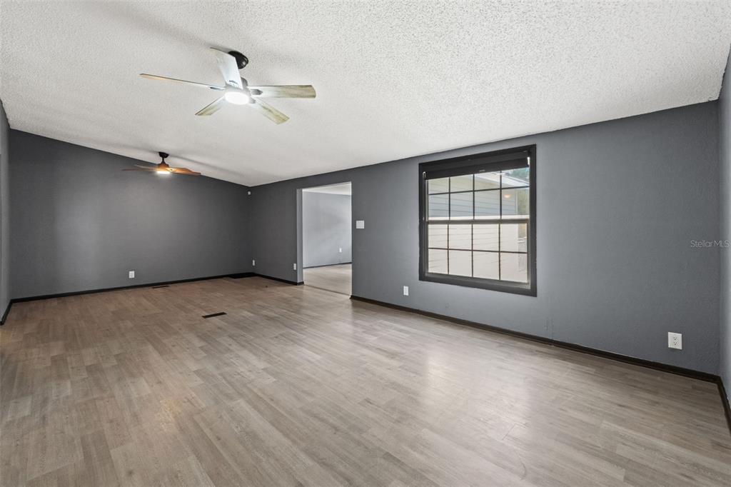 7610 County Road 663 Bushnell, FL 33513 - Photo 18 of 43 a view of an empty room with a window and wooden floor
