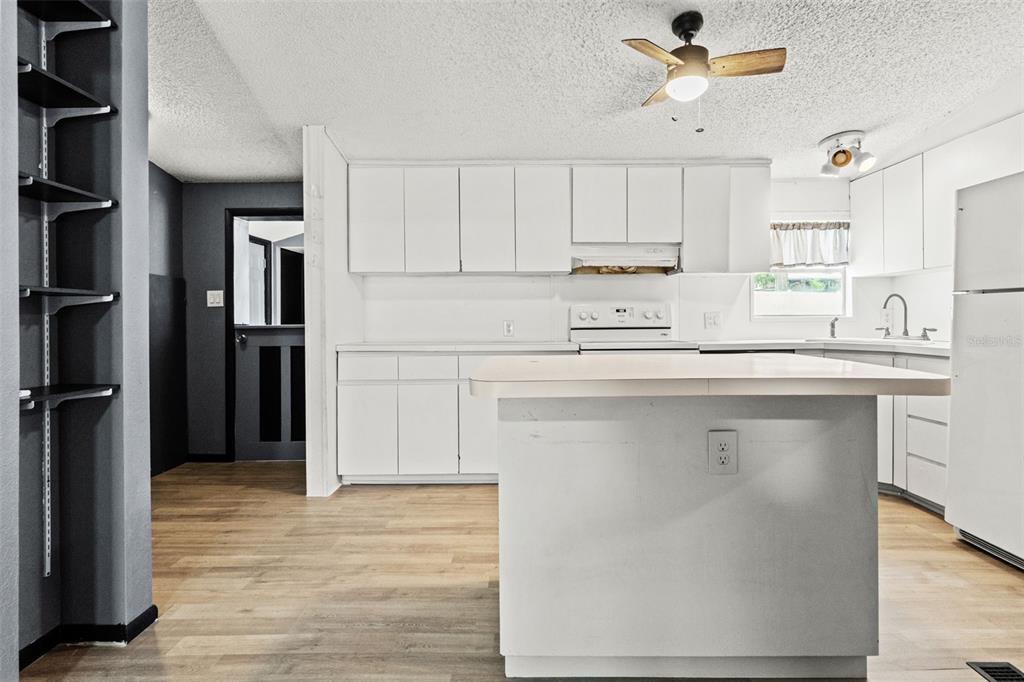 7610 County Road 663 Bushnell, FL 33513 - Photo 23 of 43 a kitchen with stainless steel appliances a refrigerator sink and cabinets