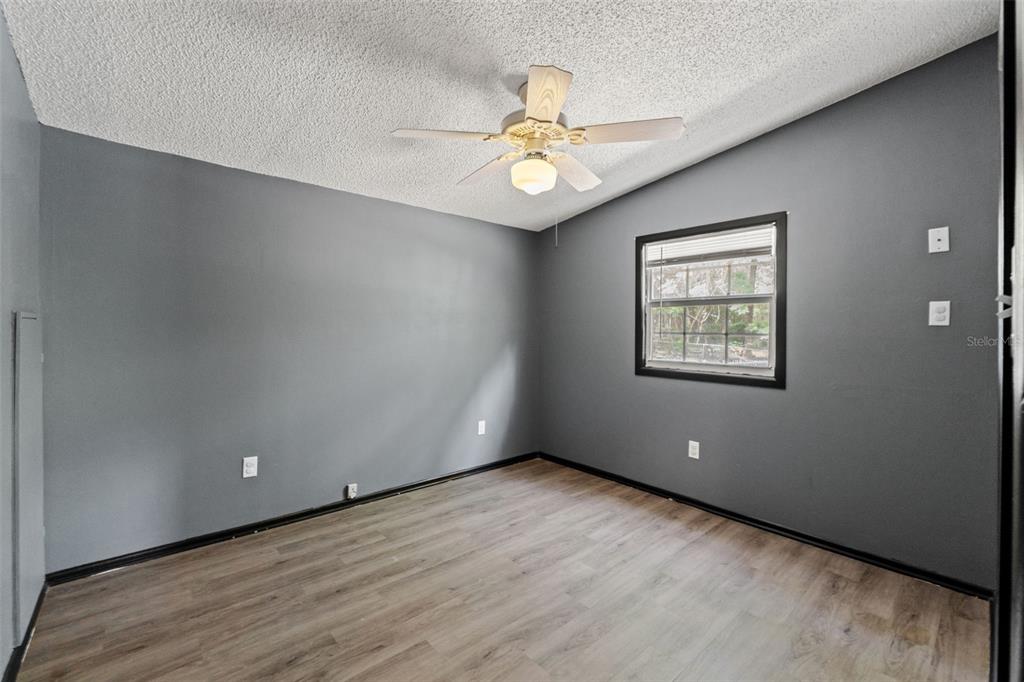7610 County Road 663 Bushnell, FL 33513 - Photo 8 of 43 an empty room with wooden floor fan and windows